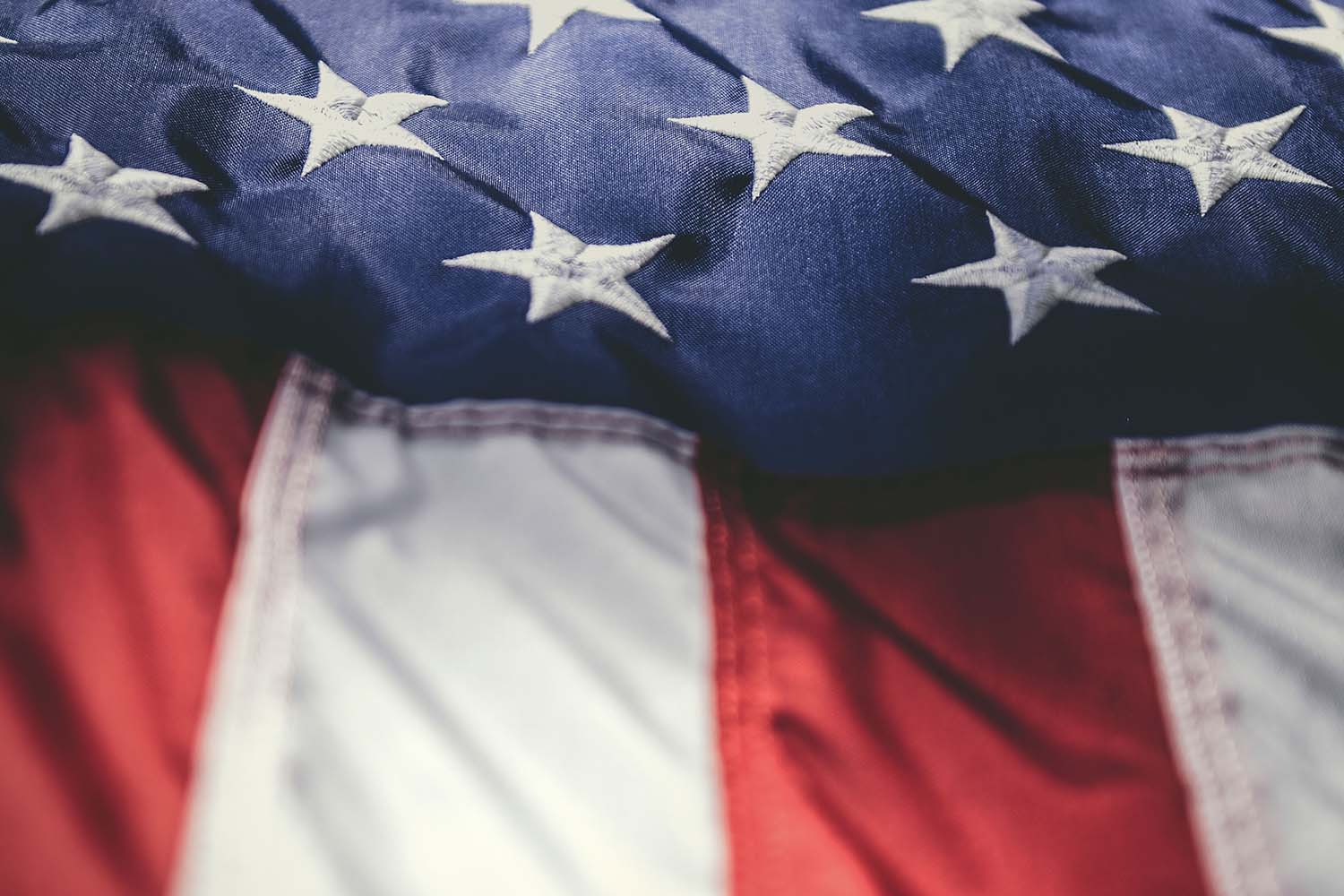A close view of a folded American flag showing its stars and stripes